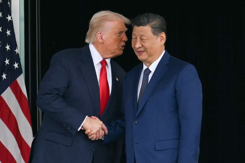 US President Donald Trump (L) and China's President Xi Jinping shake hands as they leave after their talks at the Gimhae Air Base, located next to the Gimhae International Airport in Busan on October 30, 2025.