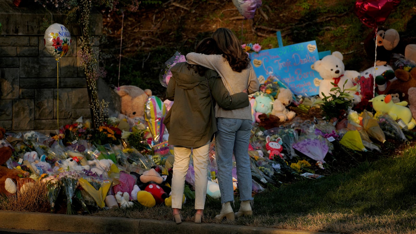 Community members embrace while visiting a memorial at the school entrance after a deadly shooting at the Covenant School in Nashville, Tennessee, March 29, 2023.