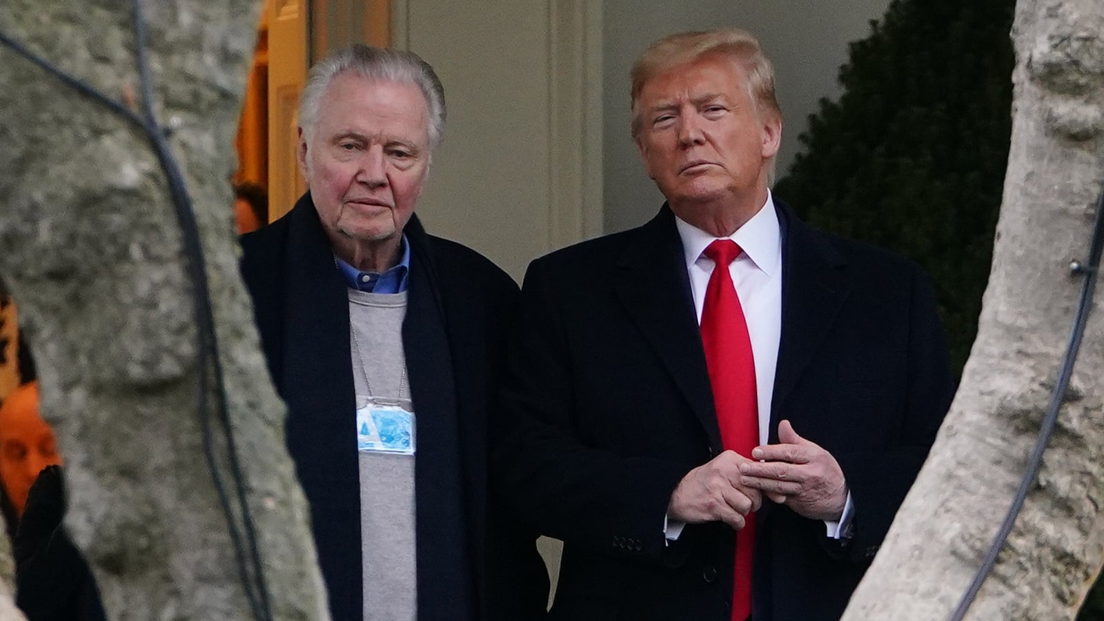 Donald Trump (R) stands with actor Jon Voight outside the Oval Office before departing from the South Lawn of the White House.