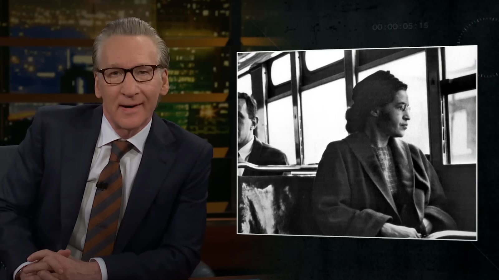 A still from a clip of Friday night's edition of Real Time with Bill Maher, featuring Maher sat at his desk alongside a photo of civil rights leader Rosa Parks.