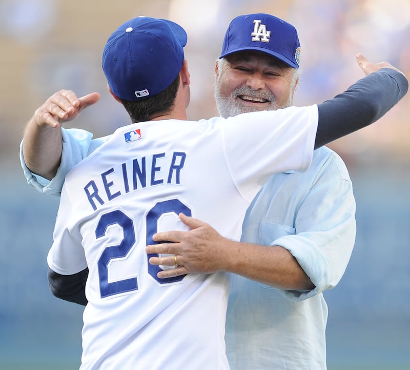 Actor/director Rob Reiner hugs his son Jake Reiner after throwing out the ceremonial pitch prior to a baseball game