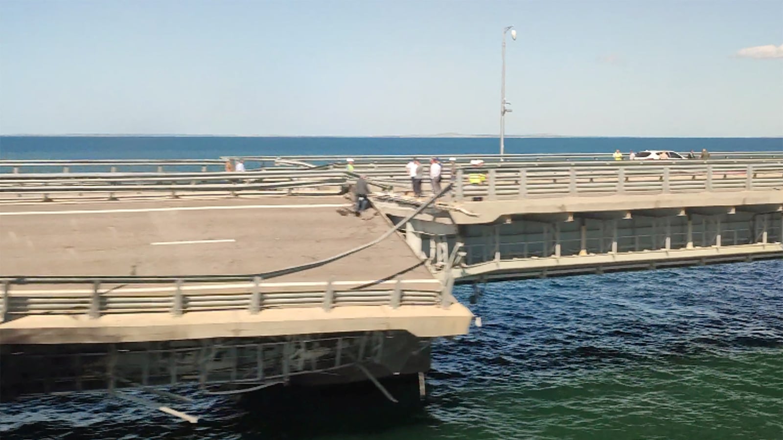 The section of a road split and sloping to one side following an alleged attack on the Crimea Bridge, that connects the Russian mainland with the Crimean peninsula across the Kerch Strait, in this still image from video taken July 17, 2023.