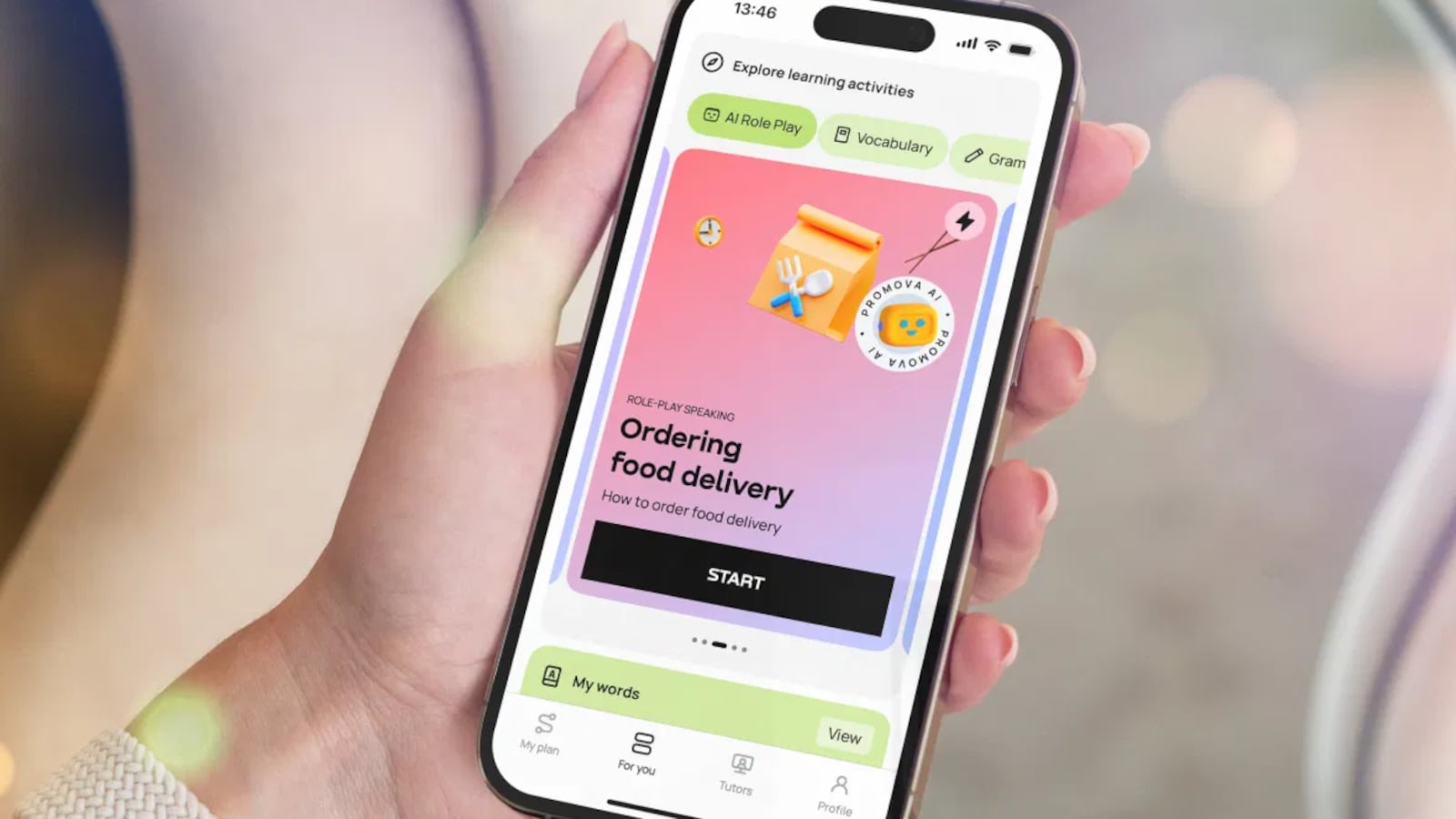 Hand holding phone showing Promova, a language learning app