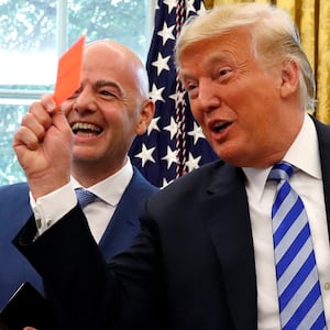U.S. President Donald Trump holds up a red card as he meets with FIFA President Gianni Infantino in the Oval Office of the White House in Washington, U.S., August 28, 2018.