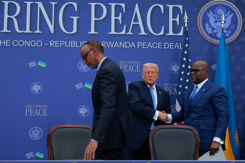 President Donald Trump (C) congratulates Rwandan President Paul Kagame (L) and Democratic Republic of Congo President Felix Tshisekedi after they signed a peace accord at the Donald J. Trump Institute of Peace on December 04, 2025 in Washington, DC.