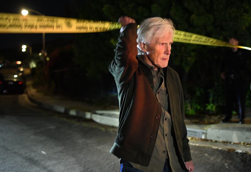 Keith Morrison crosses the police tape down the street from where Matthew Perry's house in Pacific Palisades Saturday night.