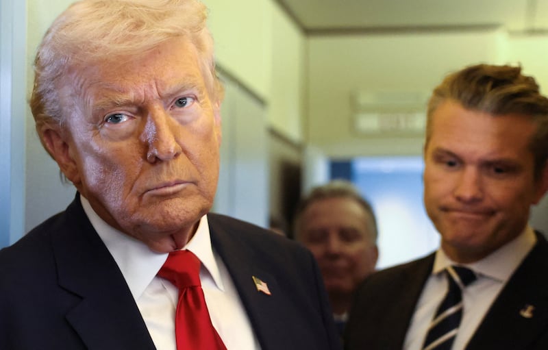 President Donald Trump, with Secretary of Defense Pete Hegseth at his side, looks on as he speaks to reporters aboard Air Force One on a flight from Dover, Delaware, to Miami, Florida, U.S., March 7, 2026.
