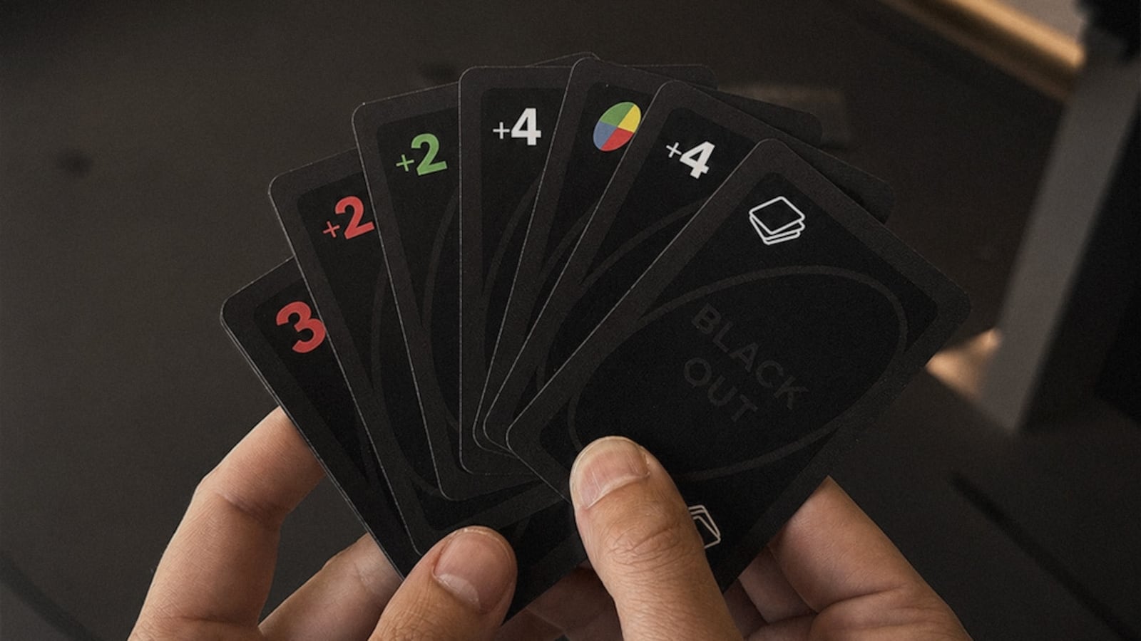 Hands holding the Blvck Paris x UNO® Deck Card (Blvck Edition)