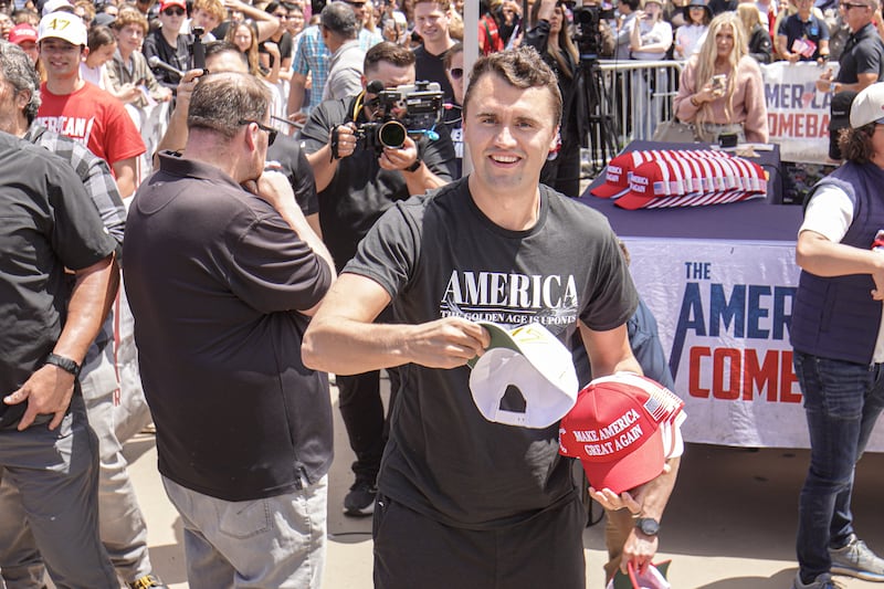 Charlie Kirk, founder of Turning Point USA, throws hats to the public.