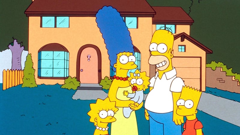 A still of a 90s episode of The Simpsons shows the entire Simpsons family posing outside of their house.
