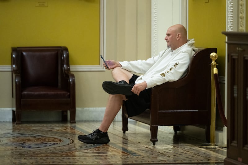 Senator John Fetterman looks at his phone in between Senate votes at the US Capitol in Washington, DC, November 10, 2025.