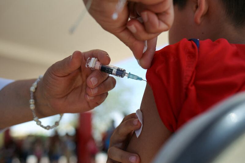 FILE PHOTO: A health worker administers a dose of the measles vaccine to a child during a measles vaccination drive in Ciudad Juarez, Mexico, June 15, 2025. REUTERS/Carlos Sanchez/File Photo