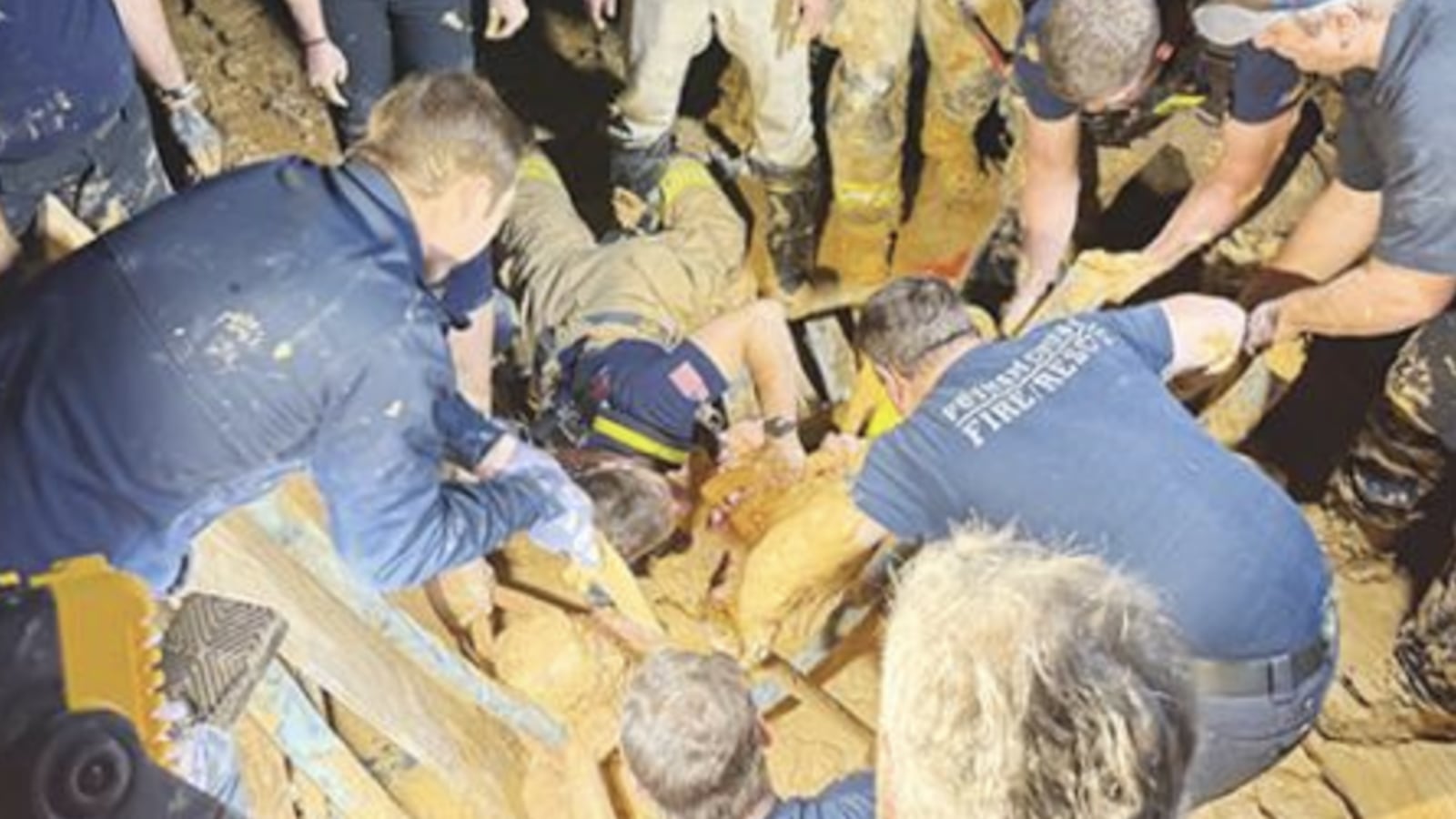 Rescue workers from numerous agencies work to dig out Jacksonville resident Andrew Giddens from quicksand at a Melrose borrow pit.