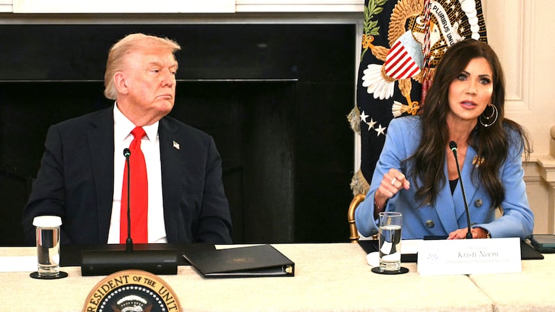 US President Donald Trump listens to Homeland Security Secretary Kristi Noem