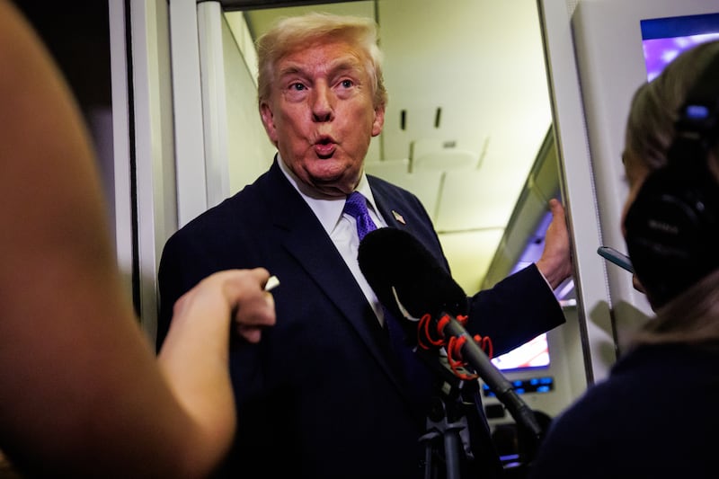 IN FLIGHT - FEBRUARY 06: U.S. President Donald Trump reacts after a reporter tells him that U.S. Vice President J.D. Vance was booed during the Opening Ceremony of the 2026 Winter Olympics during a gaggle with reporters while aboard Air Force One on February 6, 2026 en route to Palm Beach, Florida. The President is spending the weekend at Mar-a-Lago, his private club. (Photo by Samuel Corum/Getty Images)