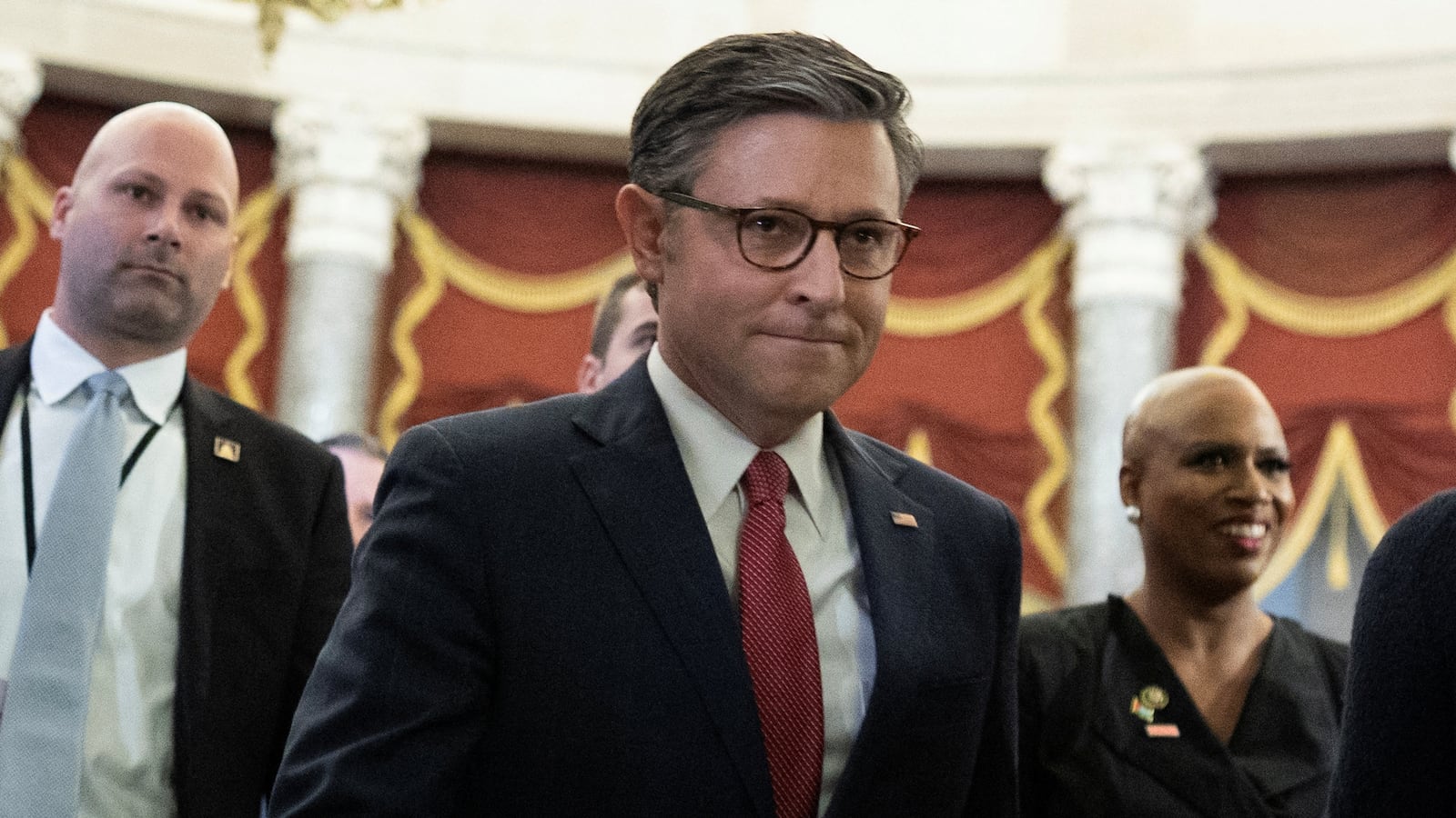 Mike Johnson walks through the U.S. Capitol in a suit and tie.