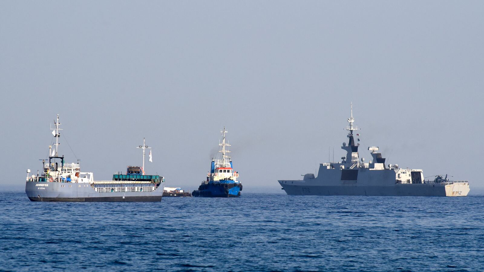 The barge Jennifer, part of a three ship flotilla carrying food aid for Gaza, sails next to the French frigate Courbet as the flotilla departs the port of Larnaca in Cyprus on March 30, 2024.