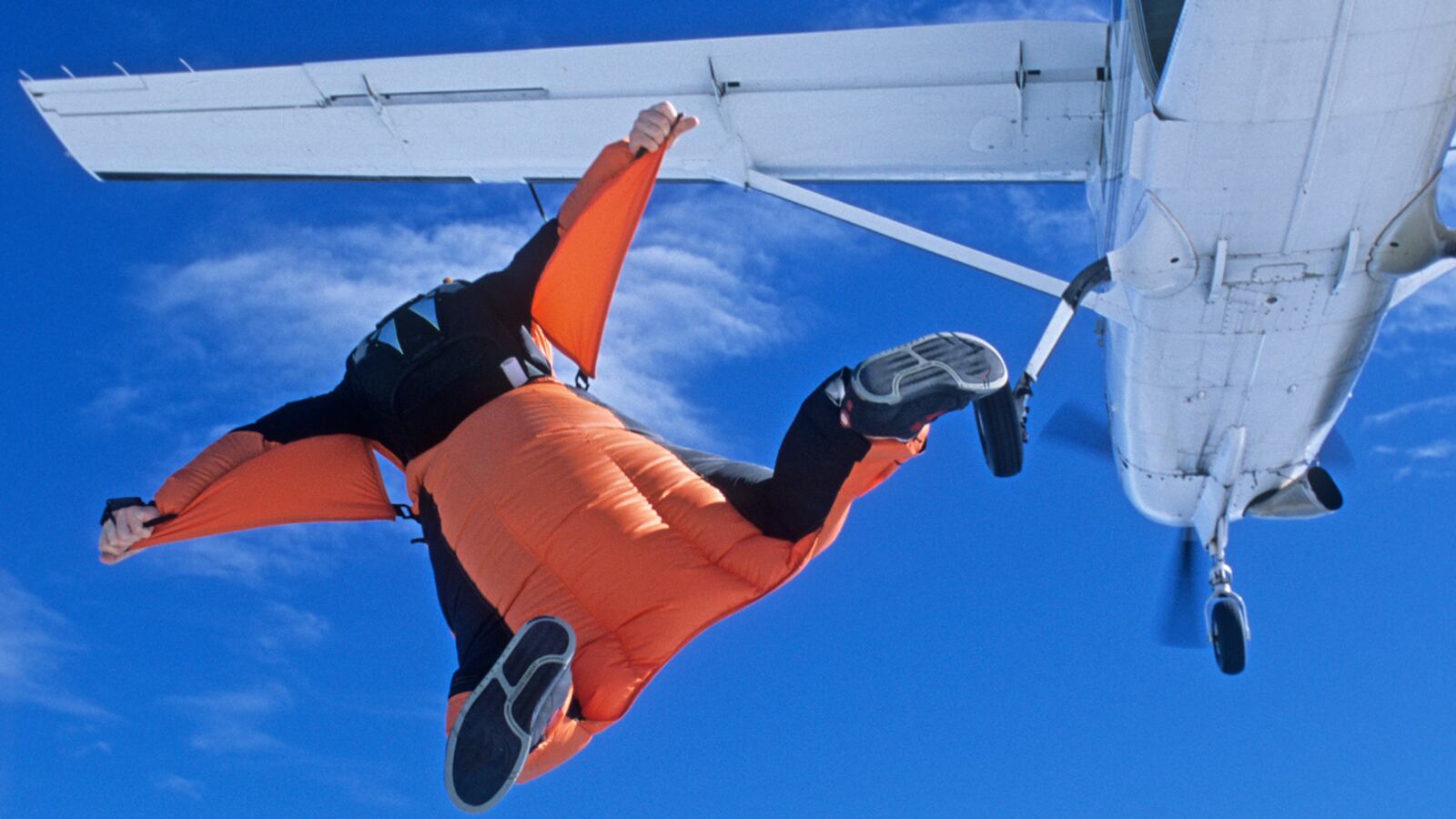 Stock image of a wingsuit skydiver jumping from a plane.