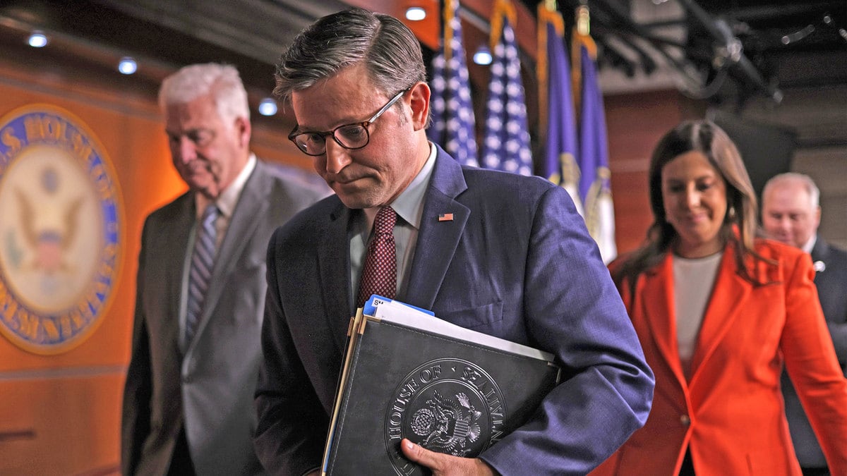 A picture of Mike Johnson walking out of a news briefing. He is flanked by Tom Emmer, Elise Stefanik, and Steve Scalise
