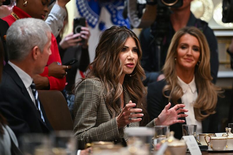 US Secretary of Homeland Security Kristi Noem speaks (C), alongside Secretary of Energy Chris Wright (L) and Administrator of the Small Business Administration Kelly Loeffler (R), during a Cabinet Meeting hosted by President Donald Trump in the Cabinet Room of the White House in Washington, DC on December 2, 2025. (Photo by ANDREW CABALLERO-REYNOLDS / AFP via Getty Images)