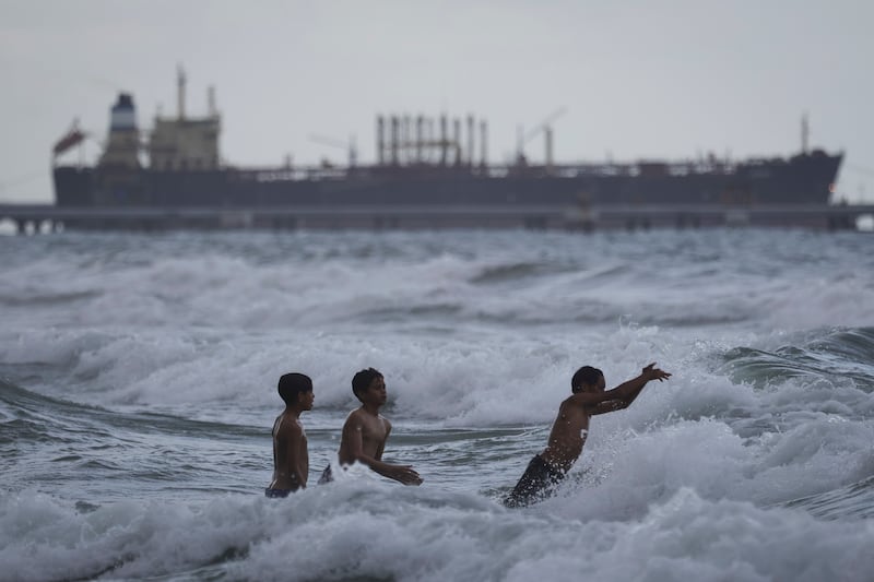 21 December 2025, Venezuela, Puerto Cabello: Children bathing near an oil tanker docked at a pier of the El Palito refinery of the state oil company PDVSA. Photo: Jesus Vargas/dpa (Photo by Jesus Vargas/picture alliance via Getty Images)
