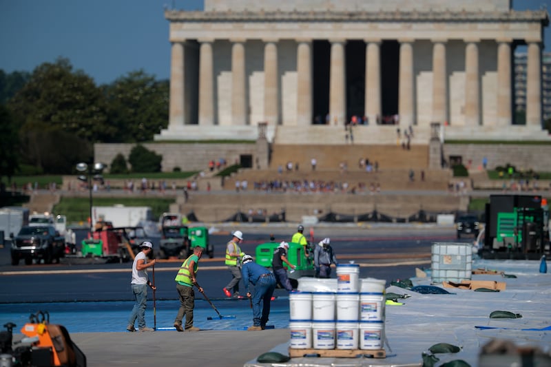 Workers spread a blue sealant onto the bottom of the Reflecting Pool with the Lincoln Memorial in the background on the National Mall on May 28, 2026 in Washington, DC.