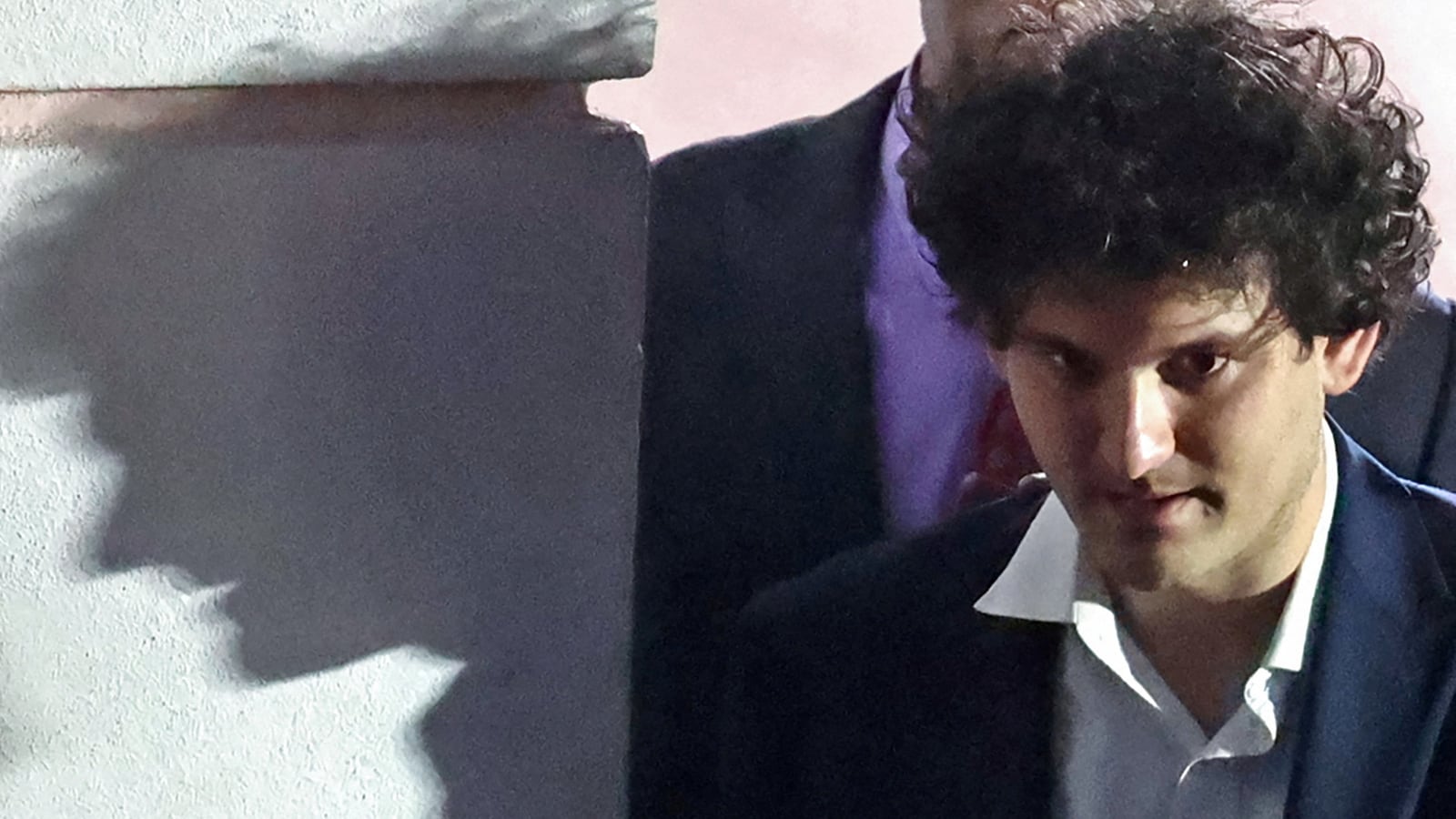 Sam Bankman-Fried, the founder and former CEO of crypto currency exchange FTX, is escorted out of the Magistrate Court building after his arrest in Nassau, Bahamas.