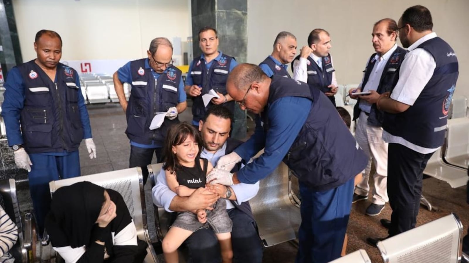 Officers take care of Palestinians after they arrive Rafah border crossing in Rafah, Gaza