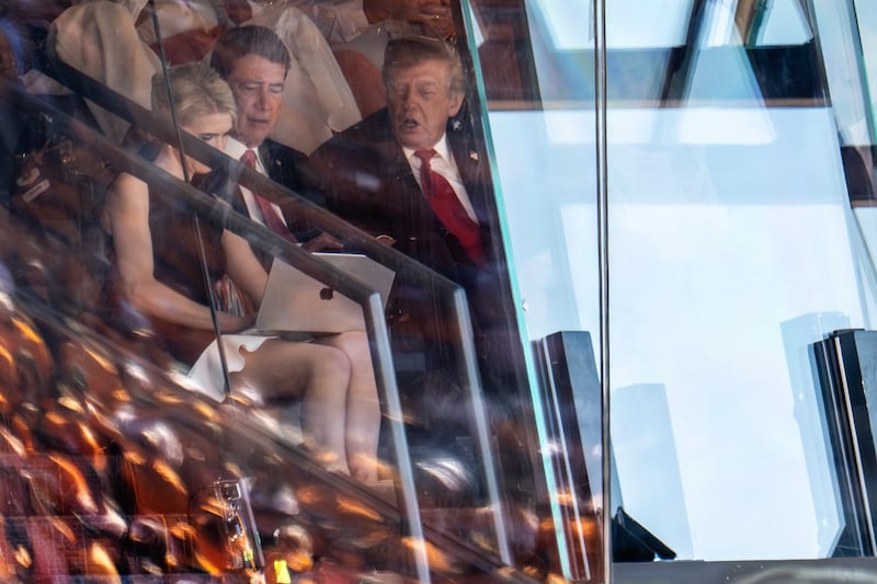US President Donald Trump (R) and US Senator Bill Hagerty, Republican of Tennessee, look at a laptop computer held by Trump's personal assistant Natalie Harp as they watch the Tennessee Volunteers play the Texas Longhorns in their Southeastern Conference (SEC) opener at Neyland Stadium in Knoxville, Tennessee, on September 26, 2026. (Photo by Jim WATSON / AFP via Getty Images)