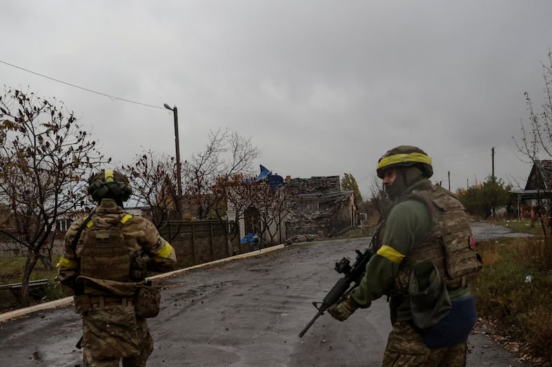 Ukrainian troops walk along a street