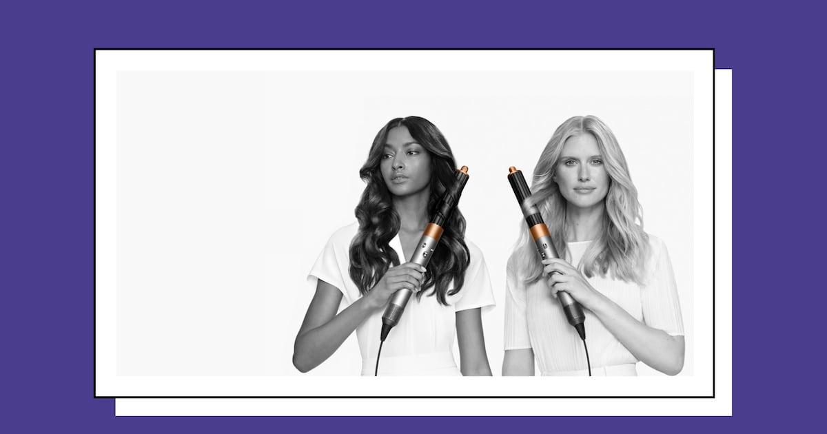 Two women holding the Dyson Airwrap multi-styler, showcasing smooth, styled hair created with the heat-controlled curling and styling tool.