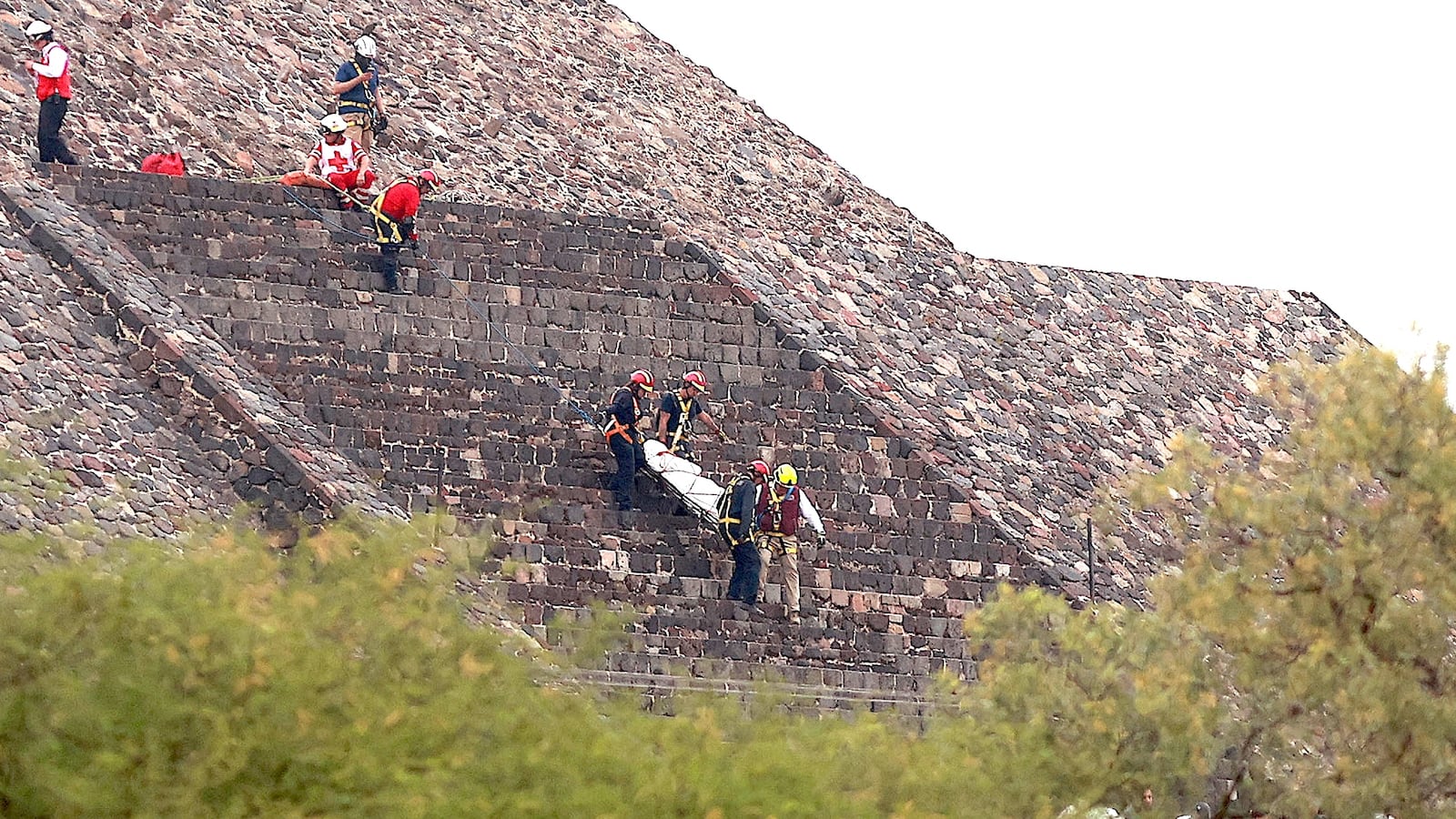 Red Cross personnel carry a body down the Pyramid of the Moon following a shooting that left at least one person dead.