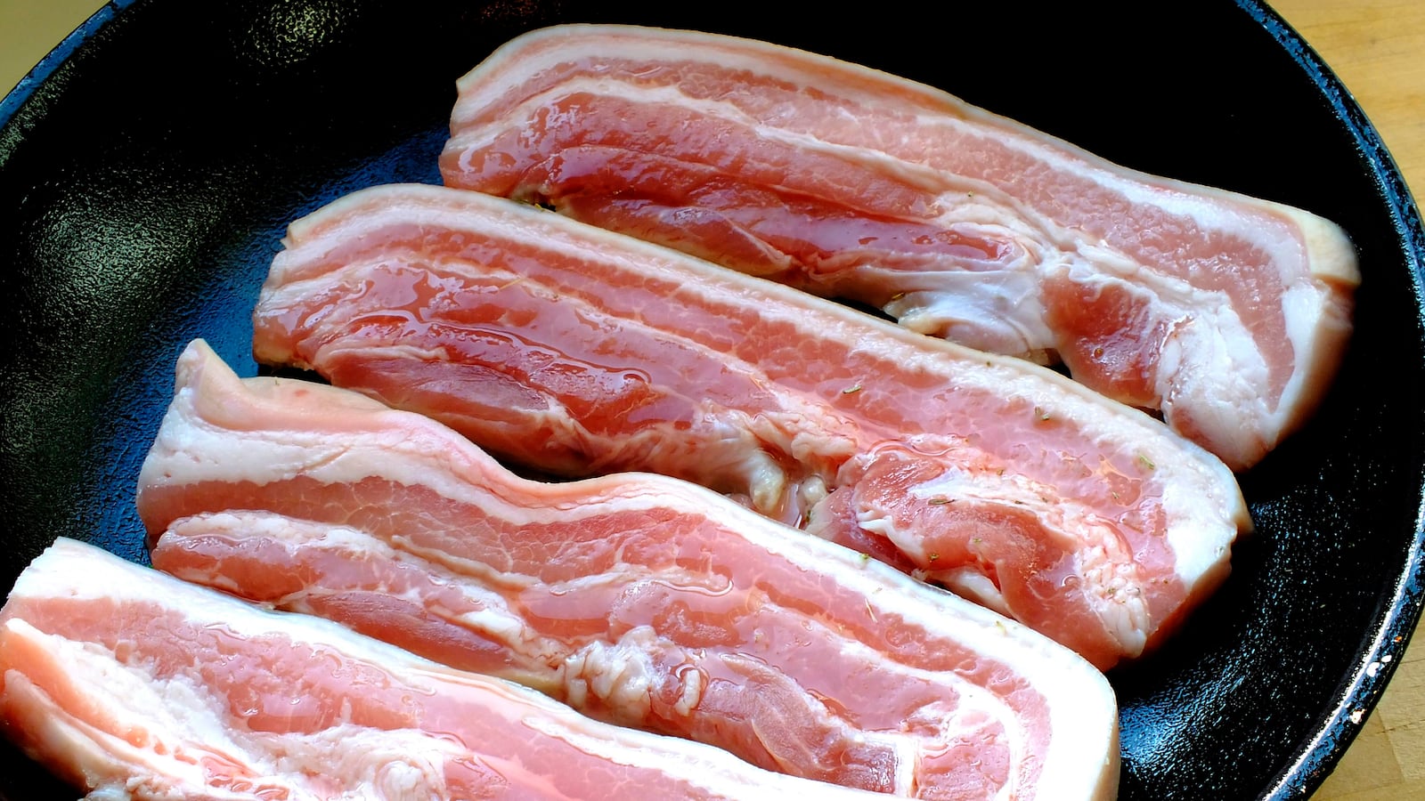 A panful of uncooked bacon.