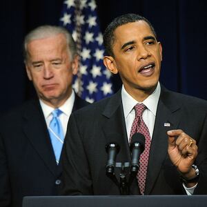Then-President Barack Obama (R) speaks as Vice President Joe Biden looks on.