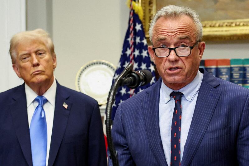 U.S. President Donald Trump listens while U.S. Secretary of Health and Human Services Robert F. Kennedy Jr. makes an announcement during a press conference to announce a link between autism and childhood vaccines and the use of popular pain medication Tylenol for pregnant women and children, claims which are not backed by decades of science, at the White House, in Washington, D.C., U.S., September 22, 2025. REUTERS/Kevin Lamarque     TPX IMAGES OF THE DAY