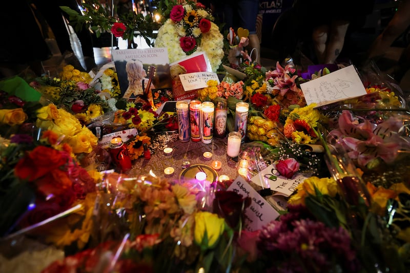 Signs, candles and flowers near Dolly Parton's star on the Hollywood Walk of Fame after it was announced that the country music icon died.