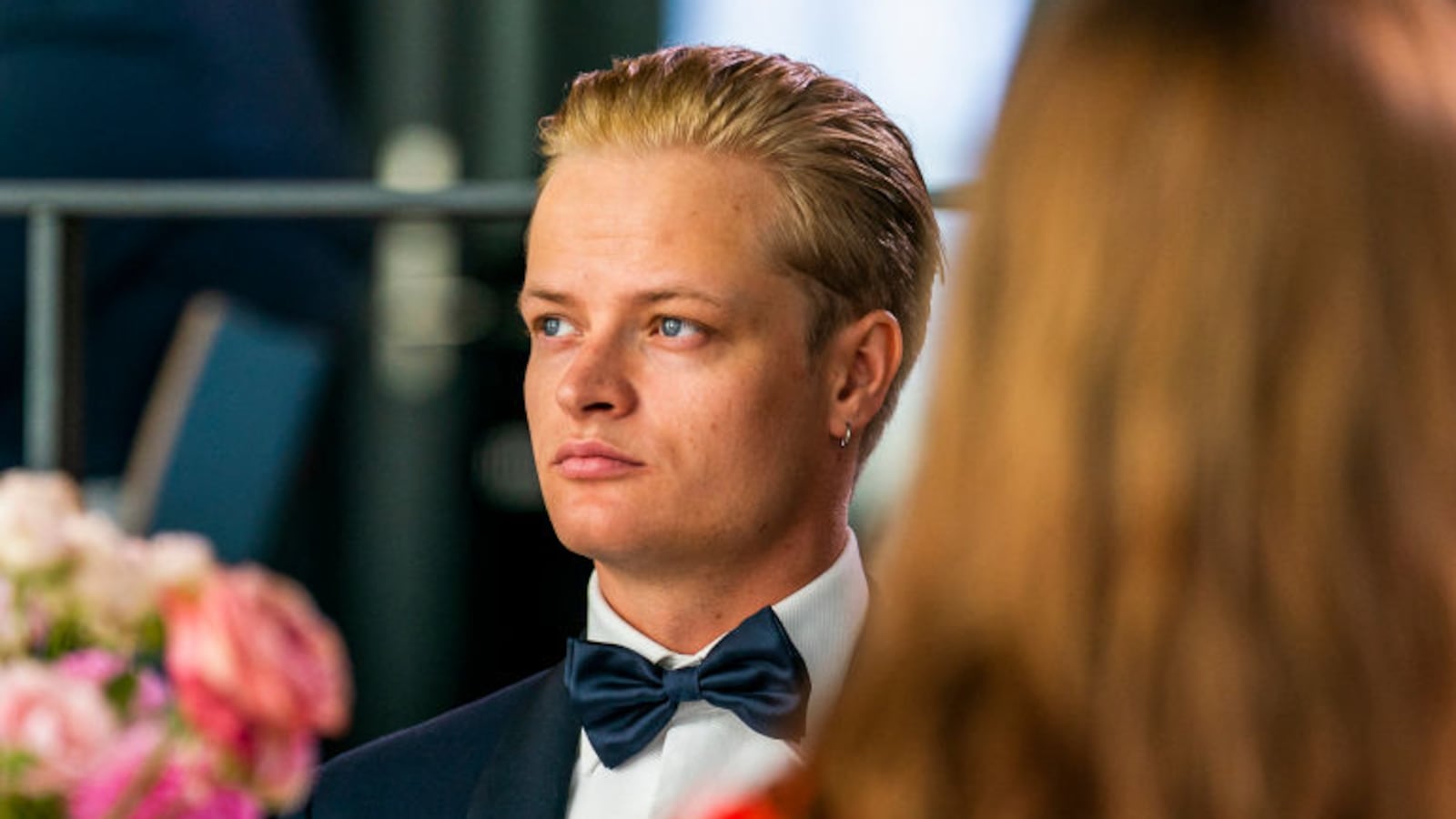 Marius Borg Høiby, wearing a suit and tie, sits at a table during an event.