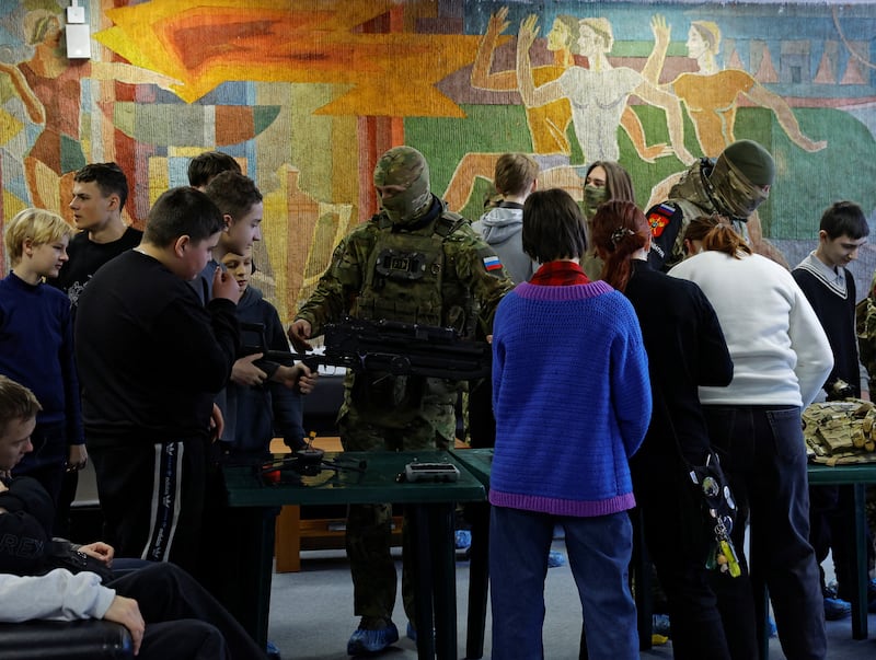Russian service members show weapons and drones to schoolchildren during an event ahead of Russia's Defender of the Fatherland Day, in the course of Russia-Ukraine conflict in Donetsk, a Russian-controlled city of Ukraine, February 22, 2026.