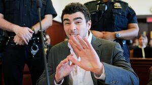 NEW YORK, NEW YORK - DECEMBER 16: Luigi Mangione talks to a photographer as he appears for a suppression of evidence hearing in the killing of UnitedHealthcare CEO Brian Thompson in Manhattan Criminal Court on December 16, 2025 in New York City. Mangione's lawyers will argue to have the evidence thrown out because police officers allegedly did not read Mangione his Miranda rights and did not have a proper warrant when they searched his backpack at a Pennsylvania McDonald's last December. He is accused of fatally shooting UnitedHealthcare CEO Brian Thompson and faces state and federal murder charges. (Photo by Seth Wenig-Pool/Getty Images)