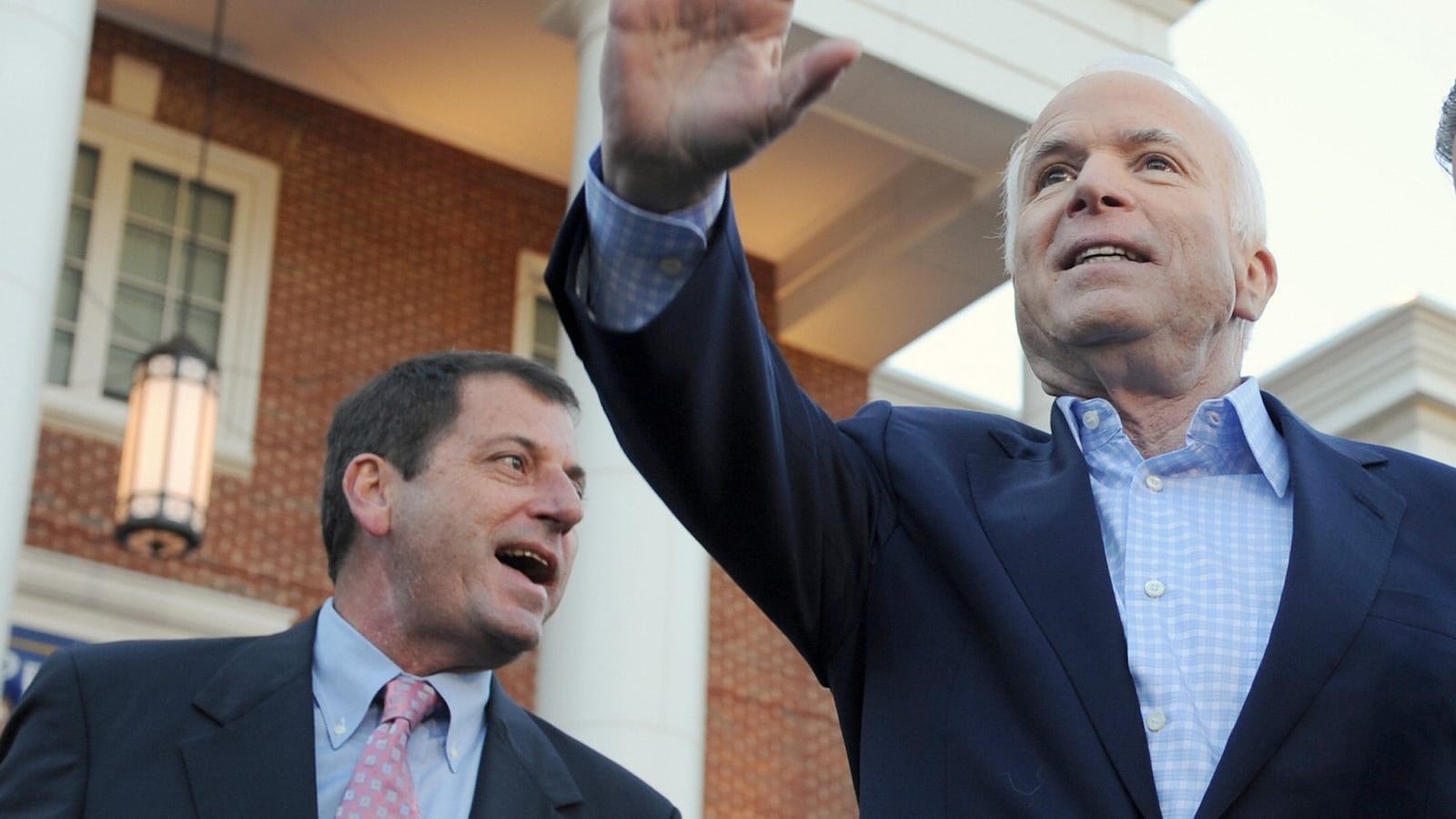 US Republican Senator from South Carolina Lindsey Graham (R) indicates the direction off the stage as Republican presidential candidate John McCain (C), backed by his son Doug McCain (L), waves at the end of a campaign rally at Christopher Newport University in Newport News, Virginia, on November 1, 2008.