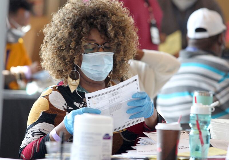 Fulton County election workers examine ballots while vote counting at State Farm Arena on November 5, 2020, in Atlanta.