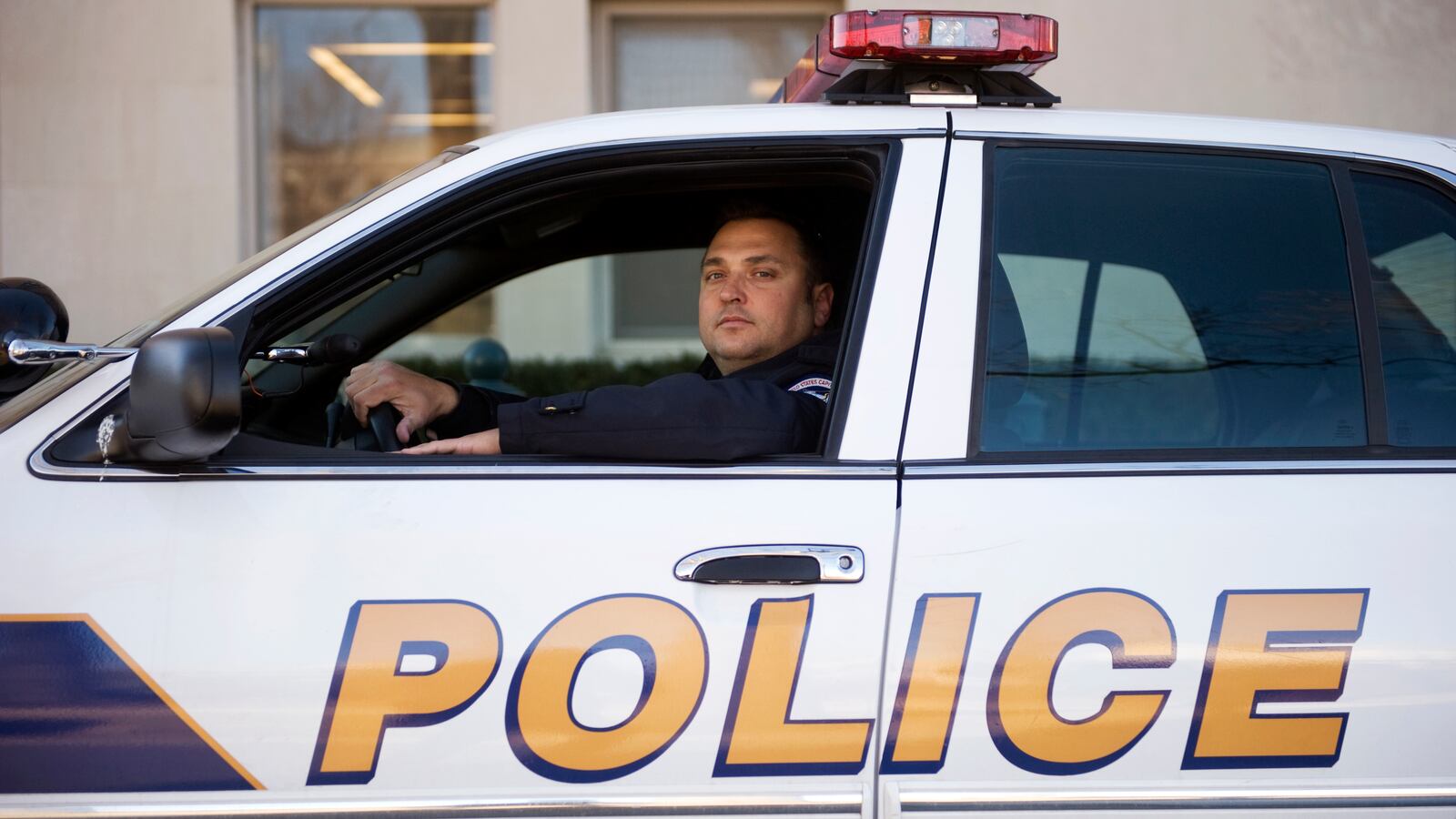 Michael Riley poses for a photo inside a Capitol Police car 2011.
