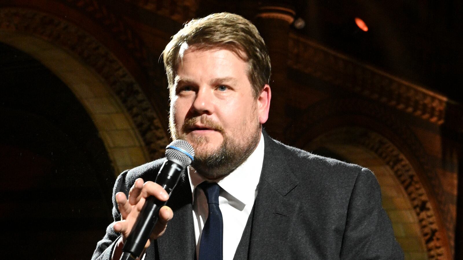 James Corden on stage with microphone
