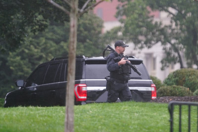 A U.S. Secret Service agent walks holding his weapon after alleged gunshots were heard nearby, at the White House in Washington, D.C., U.S., May 23, 2026.