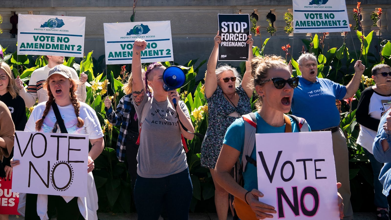 Protesters hold signs to vote no on Amendment 2, which would add a permanent abortion ban to Kentuckys state constitution