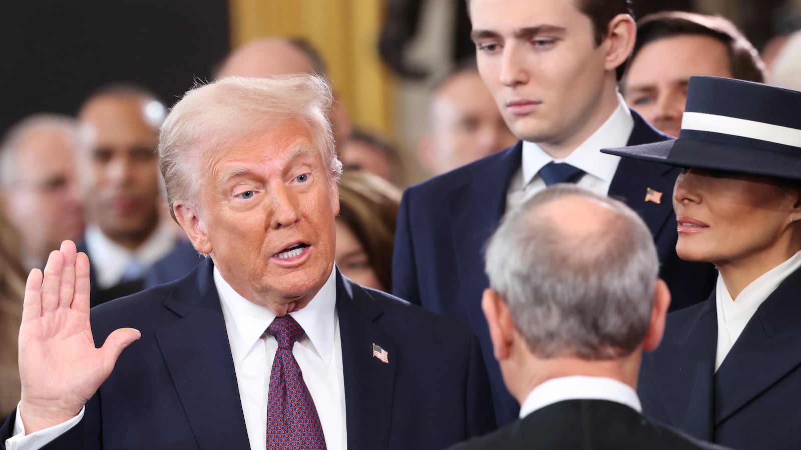 Donald Trump takes the oath of office as Barron Trump and Melania Trump look on during inauguration ceremonies in the U.S. Capitol Rotunda.