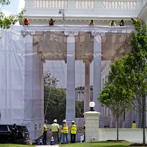 Workers place a protective cover over scaffolding surrounding the North Portico of the White House in Washington, DC on July 9, 2026.