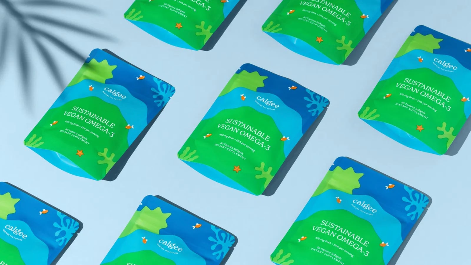 Multiple packages of Calgee Sustainable Vegan Omega-3 dietary supplement displayed on a light blue surface, showcasing vibrant green and blue designs with oceanic elements.