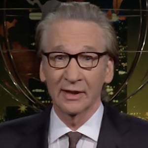 Bill Maher stands on the set of his eponymous late-night show during the monologue segment.