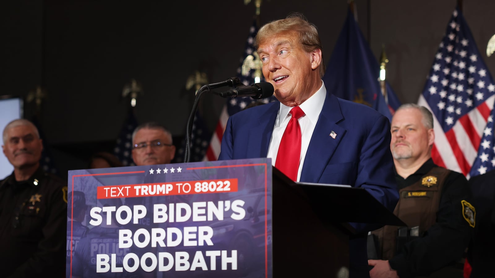 Donald Trump with a sign saying "Stop Biden's Border Bloodbath"